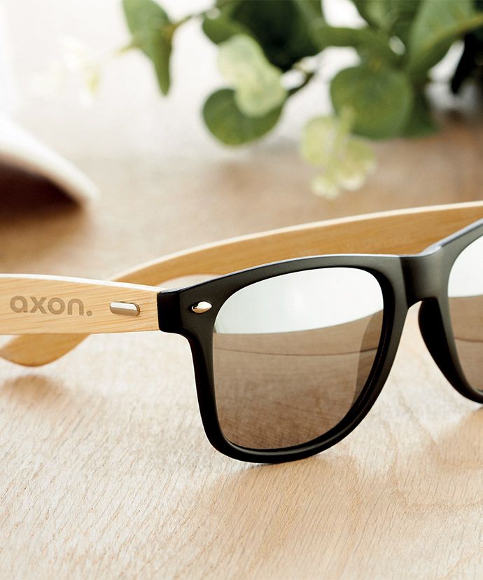 Solbriller med logo på et bord. Reklameartikler til sommeren.