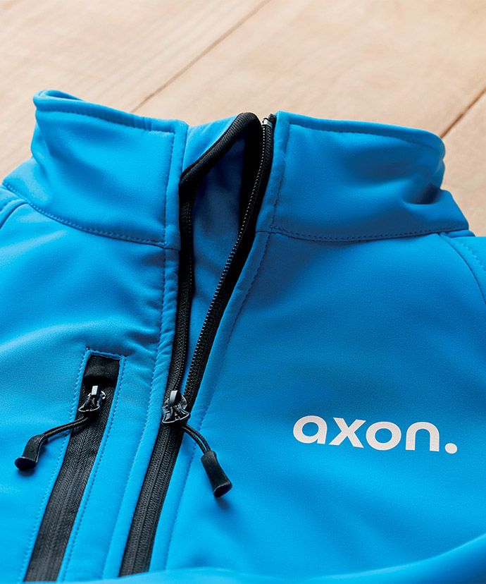 Blå jakke med logo på et bord. Reklametøj til firmaer.